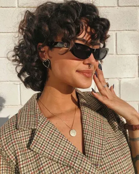 Una chica con anteojos luciendo un corte Pixie mullet Una chica con anteojos luciendo un corte Pixie mullet