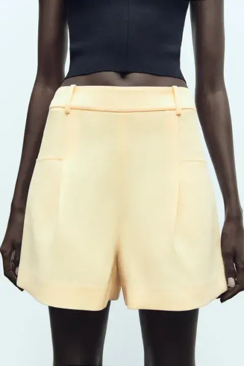 Una mujer usando un short en color amarillo Una mujer usando un short en color amarillo