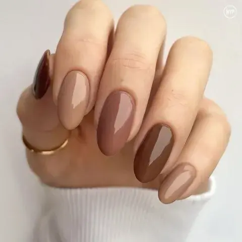 Las uñas de una mujer pintadas de color marrón Las uñas de una mujer pintadas de color marrón