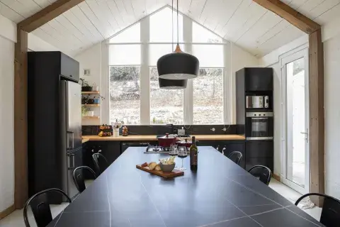 Mesada, estantes de lenga y muebles de MDF negro (todo, arquitecto Tulio Rossini). Los troncos de roble pellín interrumpen el blanco y subrayan el perfil del techo a dos aguas. Mesada, estantes de lenga y muebles de MDF negro (todo, arquitecto Tulio Rossini). Los troncos de roble pellín interrumpen el blanco y subrayan el perfil del techo a dos aguas.
