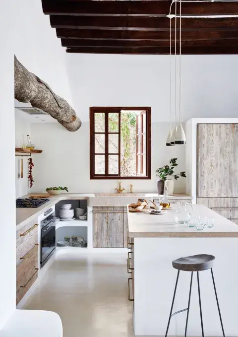 Completan la escena los muebles de madera blanqueada y un tronco al natural como terminación del volumen que contiene el extractor. Completan la escena los muebles de madera blanqueada y un tronco al natural como terminación del volumen que contiene el extractor.