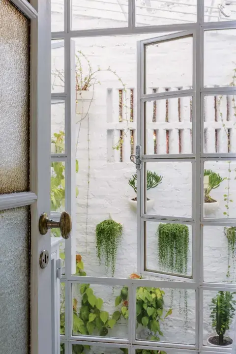 El baño iba a tener una ventana pequeña, pero al confirmar que se podía demoler la pared, optó por un ventanal de vidrio repartido que llega hasta el piso que integra el patio al entrepiso. El baño iba a tener una ventana pequeña, pero al confirmar que se podía demoler la pared, optó por un ventanal de vidrio repartido que llega hasta el piso que integra el patio al entrepiso.