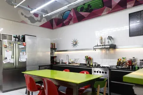 Mural de Daniel Stroomer, artista holandés que reside en Buenos Aires y firma sus grafitis como Nase Pop. La mesa tiene tapa de cuarzo europeo 'Green Fresh' de Technistone (Baremes). Reloj de pared de George Nelson (Vitra). 