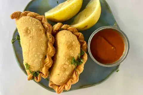 En La Pescadorita, la cocina de mar se disfruta en cada bocado, y sus empanadas encevichadas no son la excepción. Elaboradas con masa casera y un relleno de pesca fresca, mariscos en leche de tigre, choclo, cilantro, cebolla morada y lima, ofrecen un sabor original y refrescante. En La Pescadorita, la cocina de mar se disfruta en cada bocado, y sus empanadas encevichadas no son la excepción. Elaboradas con masa casera y un relleno de pesca fresca, mariscos en leche de tigre, choclo, cilantro, cebolla morada y lima, ofrecen un sabor original y refrescante.