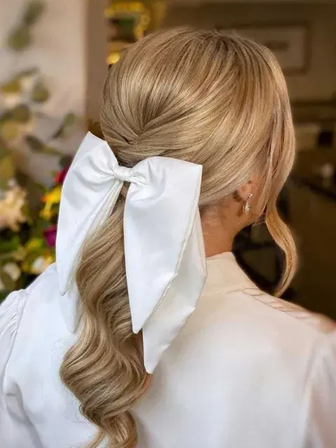 Para aportar un toque de glamour, un accesorio en forma de moño en un recogido prolijo y elegante Para aportar un toque de glamour, un accesorio en forma de moño en un recogido prolijo y elegante