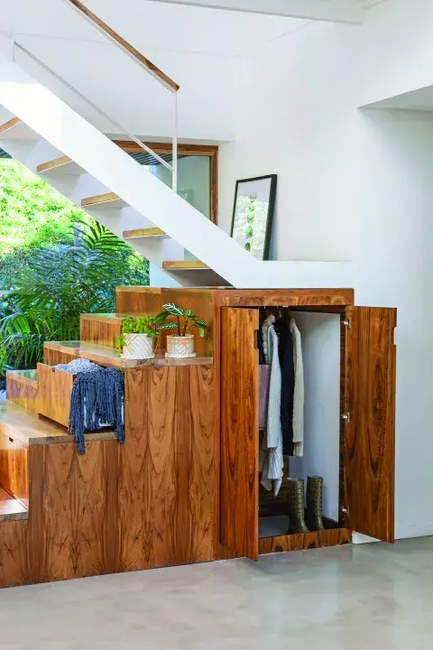 La escalera combina hierro con petiribí, macizo y enchapado.