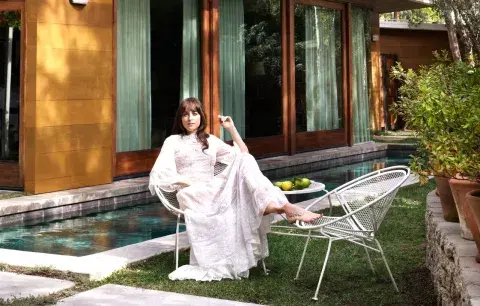 Dakota Johnson sentada en el patio de su casa de Los Ángeles.