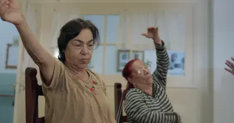 Dos residentes del Hogar en una clase de gimnasia, retratadas en Cuidadoras. Dos residentes del Hogar en una clase de gimnasia, retratadas en Cuidadoras.