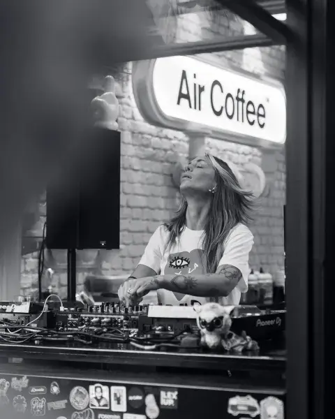 Una DJ pasando música en una coffee rave