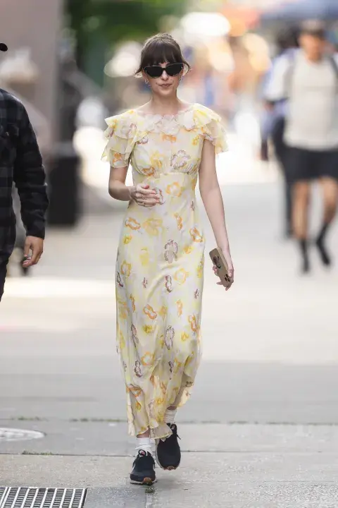 Dakota Johnson con un vestido de Dôen y zapatillas en el rodaje de Amores Materialistas. Dakota Johnson con un vestido de Dôen y zapatillas en el rodaje de Amores Materialistas.