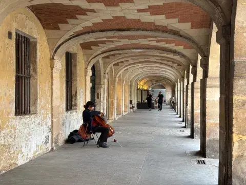Un músico deleita a los visitantes que caminan por las galerías de arte que rodean la Plaza de Vosges Un músico deleita a los visitantes que caminan por las galerías de arte que rodean la Plaza de Vosges