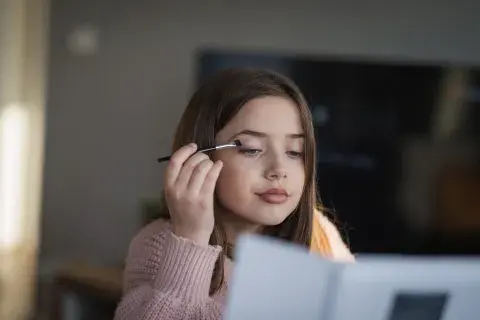 Foto de niña maquillándose.