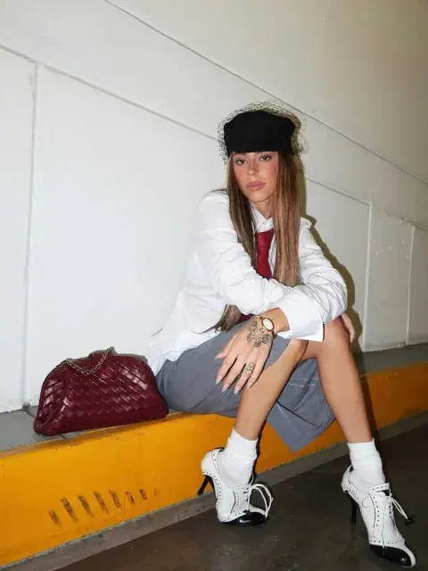 Tini Stoessel apostó por un equipo de camisa, falda y corbata en color bordó