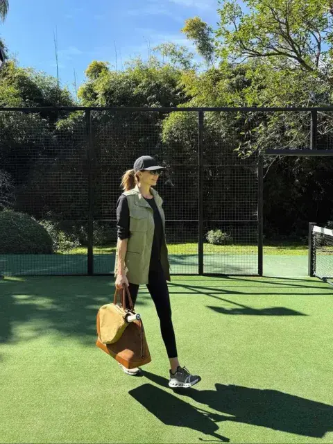 Awada eligió este diseño para una jornada de tenis al aire libre, acompañada por un conjunto total black, chaqueta verde militar y gorra en tonos tierra.