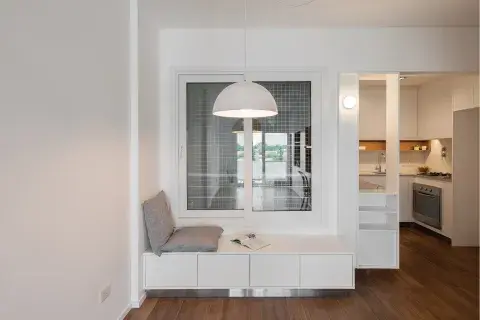 El asiento con cajones para marca el lugar del comedor. Como transición, un módulo tapa la cabecera de la mesada y, siguiendo la idea principal, agrega espacio de guardado con un botinero. 