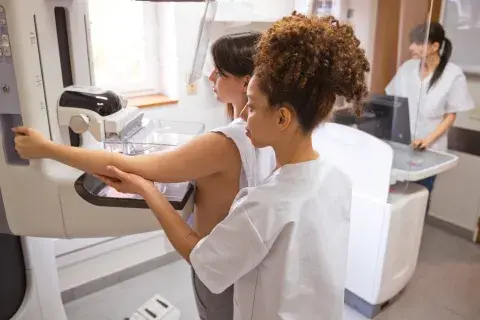 Doctora y mujer joven durante la prueba de mamografía en la sala de examen.