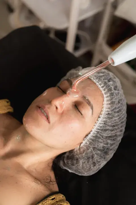 Mujer haciéndose tratamientos de alta frecuencia facial. Mujer haciéndose tratamientos de alta frecuencia facial.