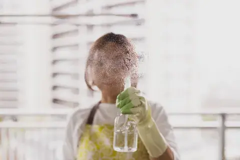 Foto de mujer limpiando ventanas.