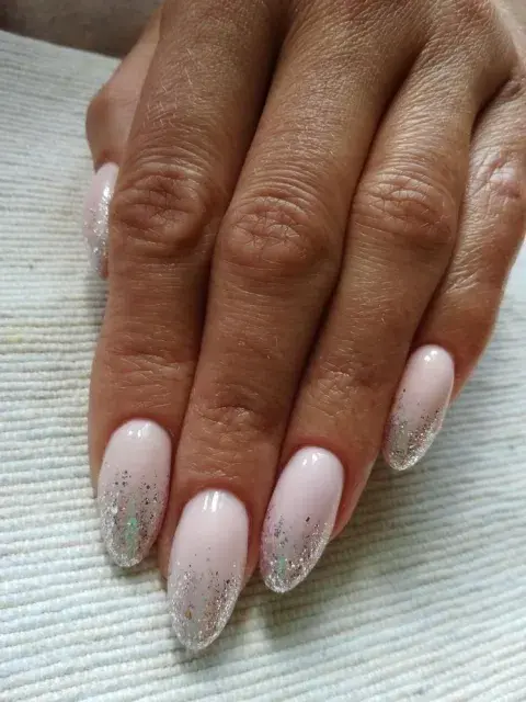 Sumale a tus uñas de diciembre brillos plateados o dorados.