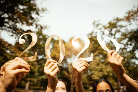 Foto de amigos sosteniendo carteles y celebrando la llegada del nuevo año 2026. 