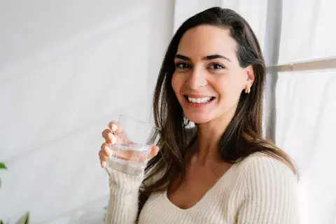 Foto de mujer hidratándose.