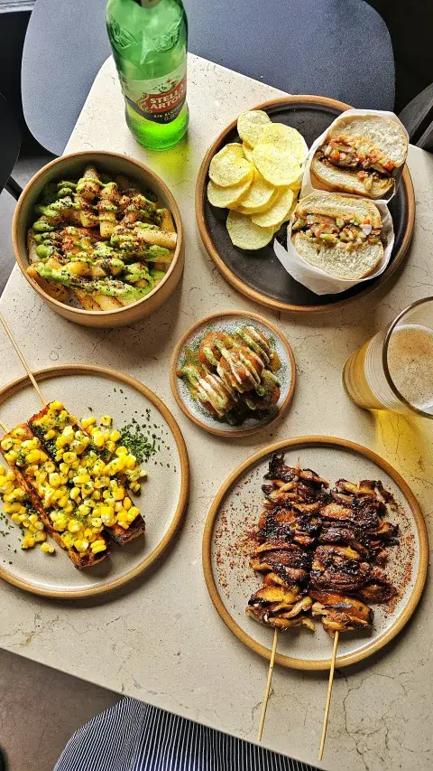 Mesa con platitos variados y una cerveza Mesa con platitos variados y una cerveza