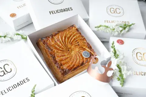 Elaborada con hojaldre y rellena de frangipane —mezcla de crema de almendras y crema pastelera—, mantiene la tradición de la fève escondida en su interior, que consagra Rey o Reina del día a quien la encuentra, junto con la clásica corona de papel. Elaborada con hojaldre y rellena de frangipane —mezcla de crema de almendras y crema pastelera—, mantiene la tradición de la fève escondida en su interior, que consagra Rey o Reina del día a quien la encuentra, junto con la clásica corona de papel.