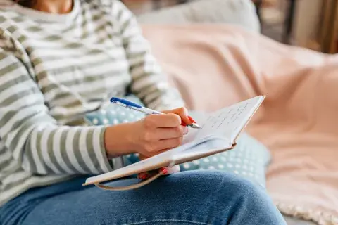Foto de mujer escribiendo una agenda.