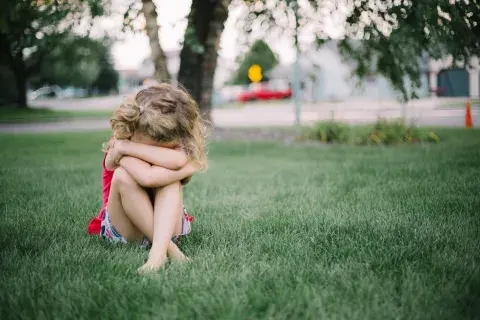 niño o niña triste sola en la plaza