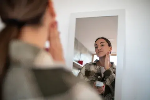 Foto de mujer limpiando su rostro.