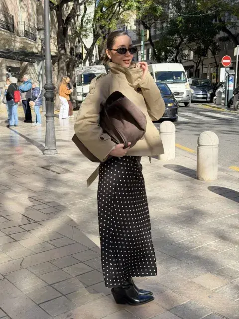 Una mujer con una campera de cuero y una pollera a lunares Una mujer con una campera de cuero y una pollera a lunares