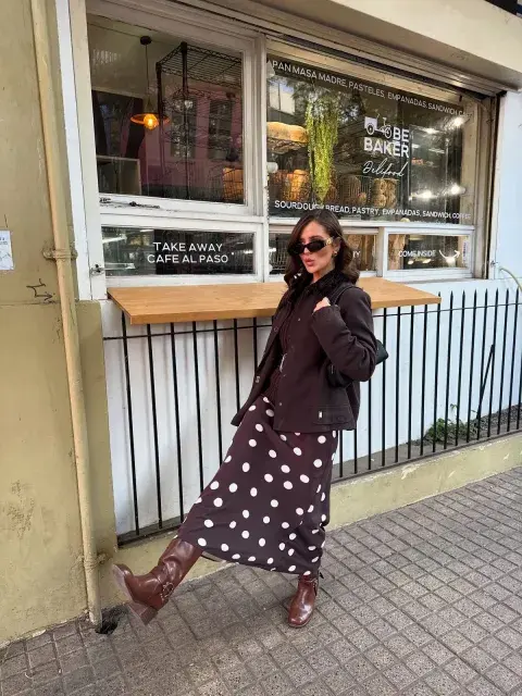Una mujer con una campera de cuero y una pollera a lunares Una mujer con una campera de cuero y una pollera a lunares