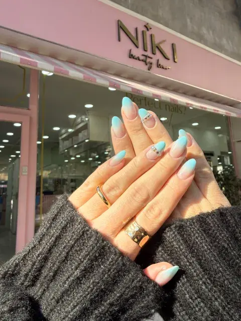 Uñas con esmalte celeste y blanco.