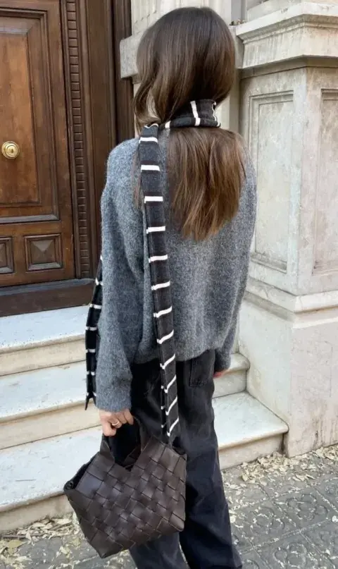 Un mujer usando una bufanda finita para el invierno 2026 Un mujer usando una bufanda finita para el invierno 2026