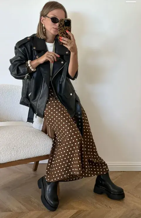 Una mujer con una campera de cuero y una pollera a lunares Una mujer con una campera de cuero y una pollera a lunares