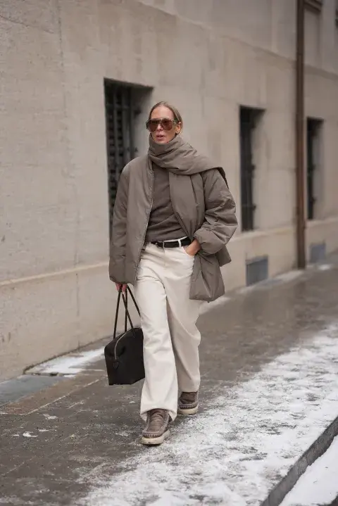 una mujer caminando por la calle abrigada por el frio