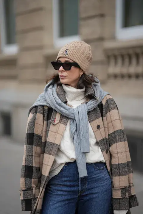 una mujer caminando por la calle abrigada por el frio