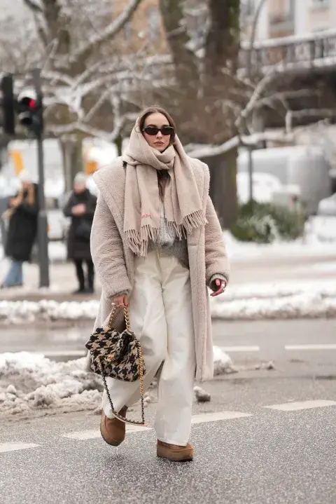 una mujer caminando por la calle abrigada por el frio