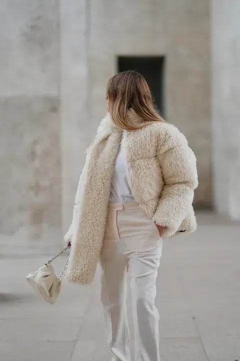 una mujer caminando por la calle abrigada por el frio