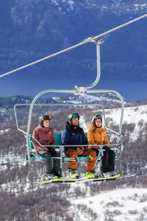 Tres personas en una aerosilla en la montaña