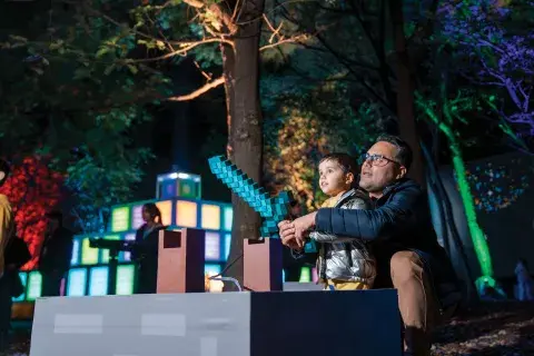 Un papá y su hijo jugando con una estructura del universo Minecraft Un papá y su hijo jugando con una estructura del universo Minecraft