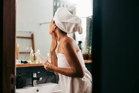 Mujer hidrtándose la piel Mujer hidrtándose la piel
