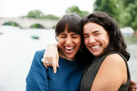 dos amigas abrazadas riendose dos amigas abrazadas riendose