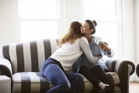Foto de amigas dándose un regalo.