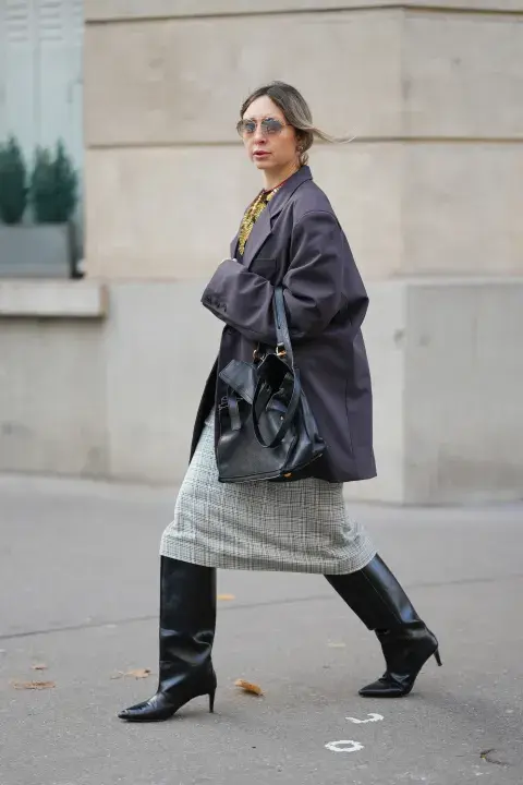 Una mujer usando botas XL y un vestido midi en color gris