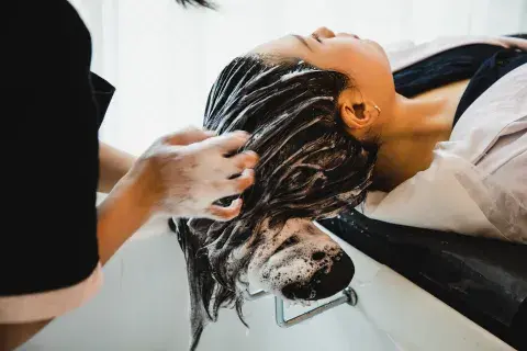 Una mujer en la peluquería lavándose el pelo Una mujer en la peluquería lavándose el pelo