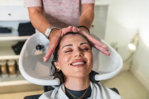 Una mujer en la peluquería lavándose el pelo Una mujer en la peluquería lavándose el pelo