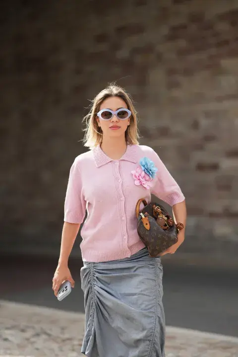 Una mujer con un cardigan en tono rosa claro Una mujer con un cardigan en tono rosa claro