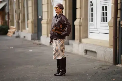 Mujer con look de pollera midi y botas