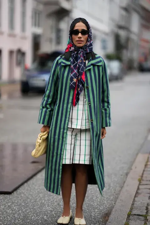 Una mujer vestida con messycore tapado de rayas en color verde y conjunto cuadrillé Una mujer vestida con messycore tapado de rayas en color verde y conjunto cuadrillé